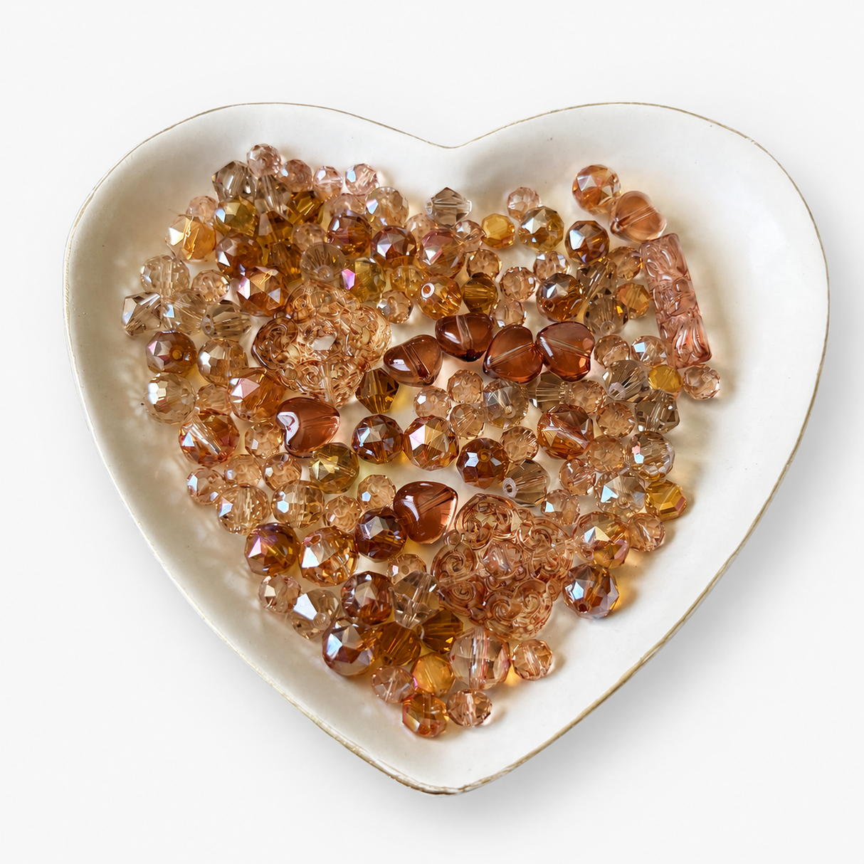 Honey Blush Luxe Mix glass bead assortment in a heart-shaped dish on a white background