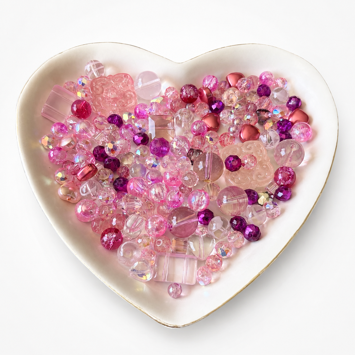 Pretty in Pink Luxe Mix glass bead assortment in a heart-shaped dish on a white background