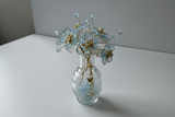 Full view of beaded flower arrangement in textured glass vase