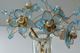 Close-up detail of handcrafted blue beaded flowers with gold accents 