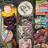 Collection of colorful stickers and pins on a clear tray