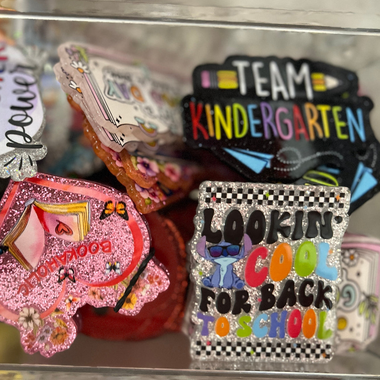 Collection of colorful brooches in a clear display case.
