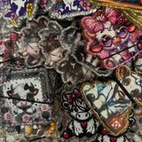 Collection of colorful embroidered patches on a textured surface