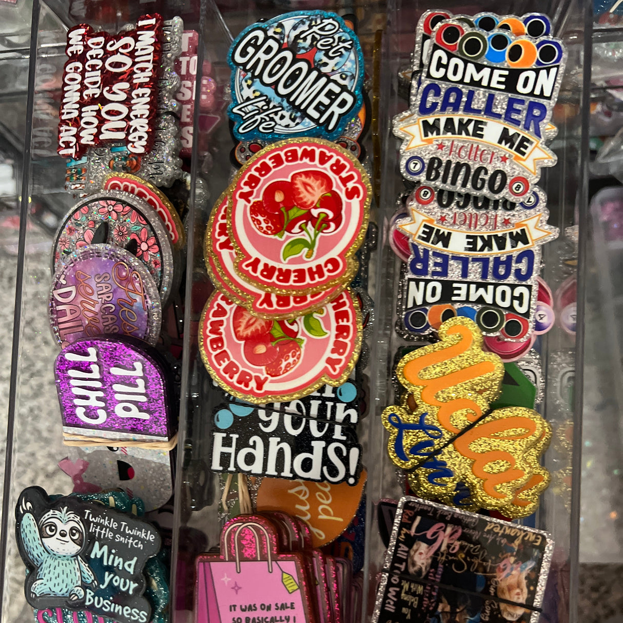 Collection of colorful pins and stickers in a clear display case.