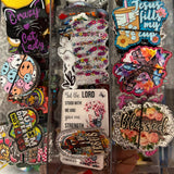 Collection of colorful magnets with various designs on a clear surface