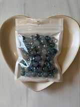 Bag of marbles on a white plate with a light background