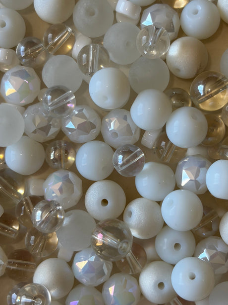 Assorted white and clear beads on a light background
