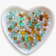 Bayou Royalty Luxe Mix glass bead assortment in a heart-shaped dish on a white background