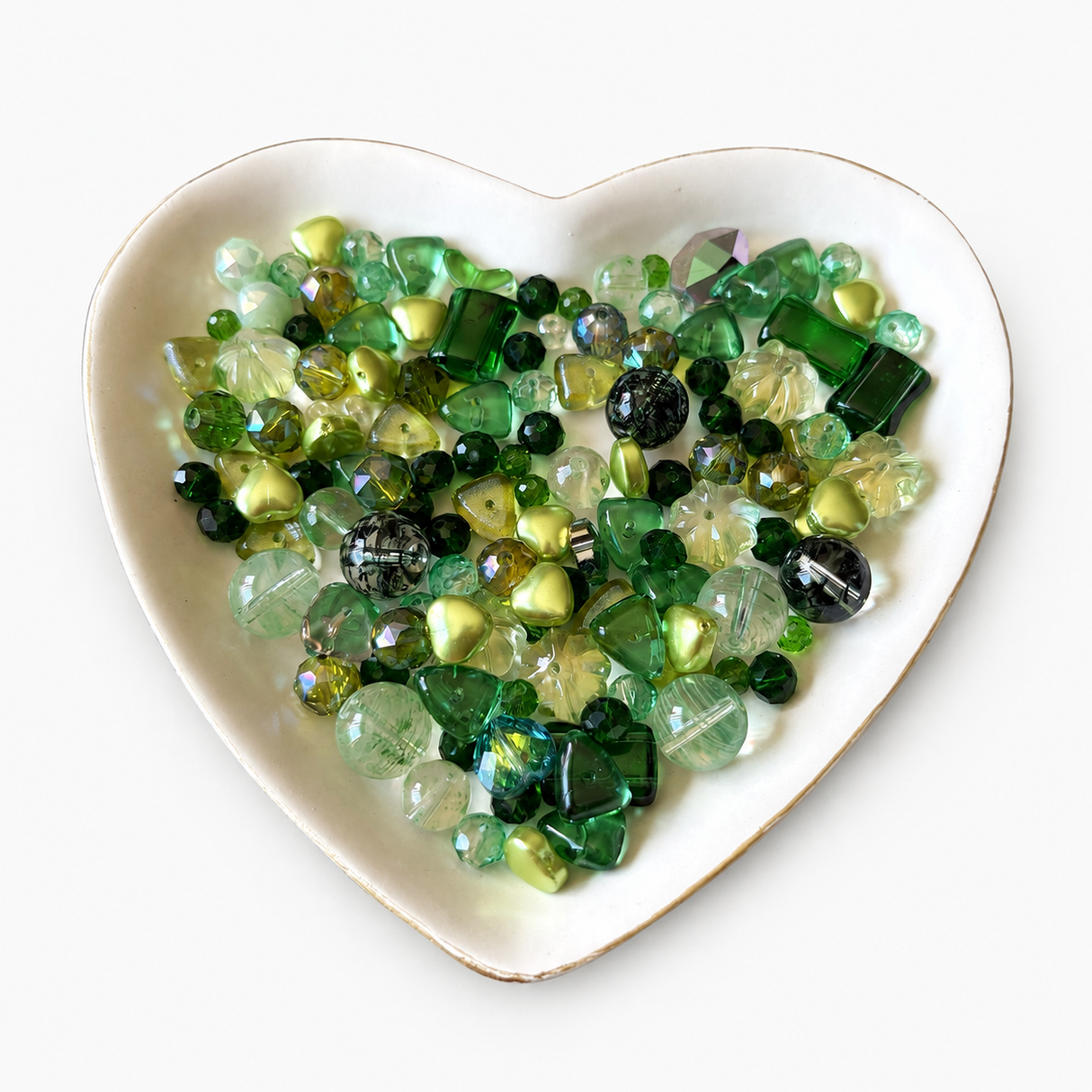 Emerald Garden Luxe Mix glass bead assortment in a heart-shaped dish on a white background