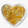 Golden Sunshine Luxe Mix glass bead assortment in a heart-shaped dish on a white background