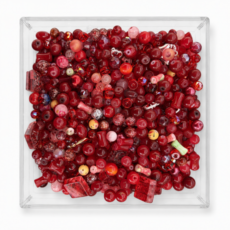 Scarlet assorted bead mix in clear tray on a soft white background