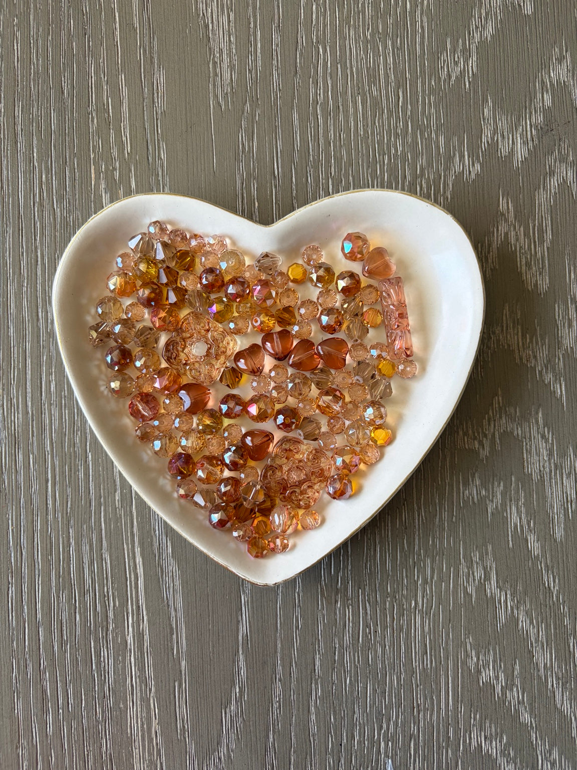 Orange Glow Bling Bling Lux Mix orange glass beads displayed in heart-shaped dish