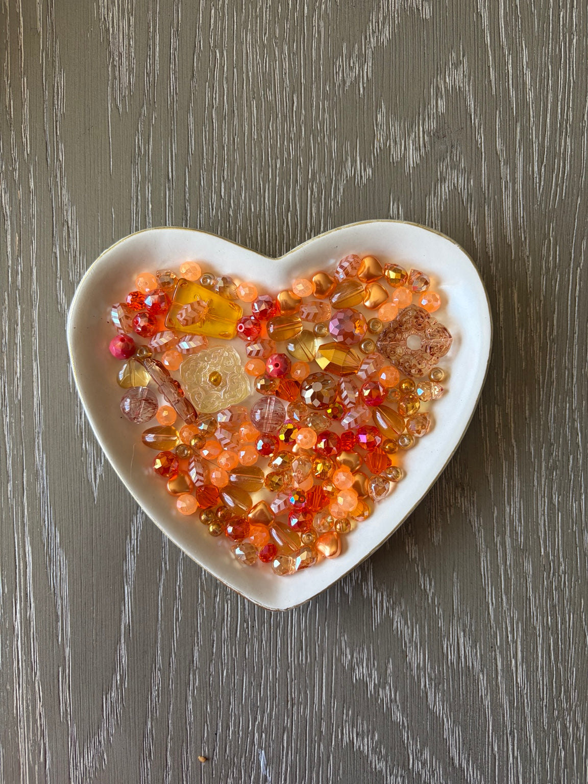 Orange Paradise Bling Bling Lux Mix orange bead assortment in heart-shaped dish