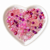Pink Champagne Bling Bling Lux Mix pink bead assortment in heart-shaped dish on white background