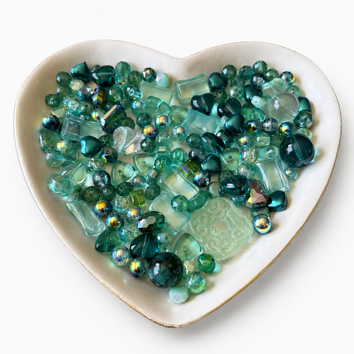 Sea Glass Luxe Mix glass bead assortment in a heart-shaped dish on a white background
